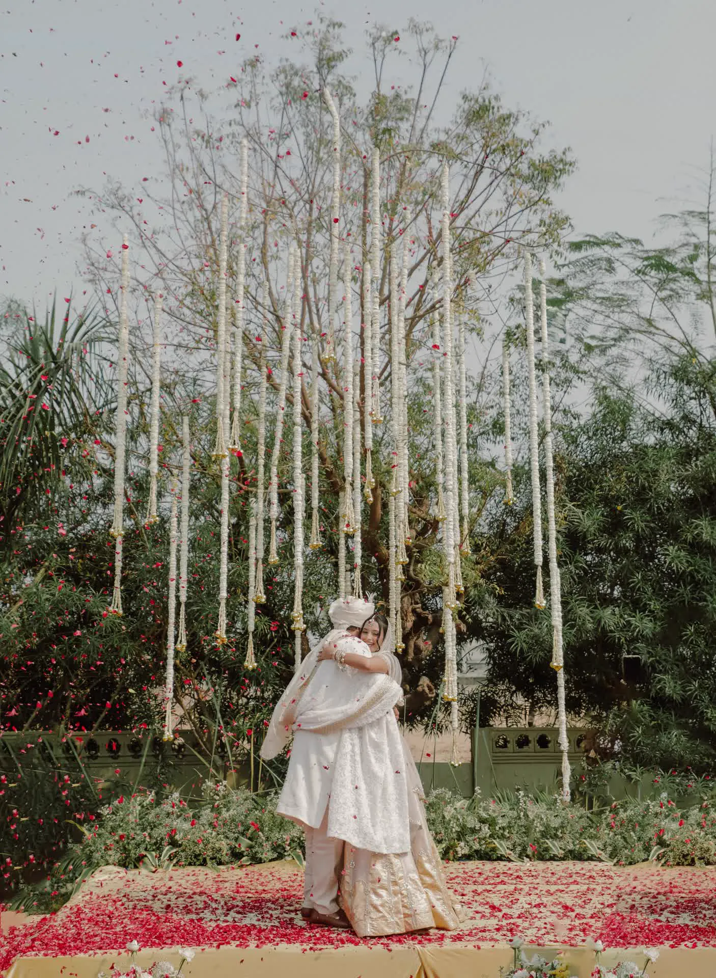 Wedding couple portrait under towering floral streamers and canopy