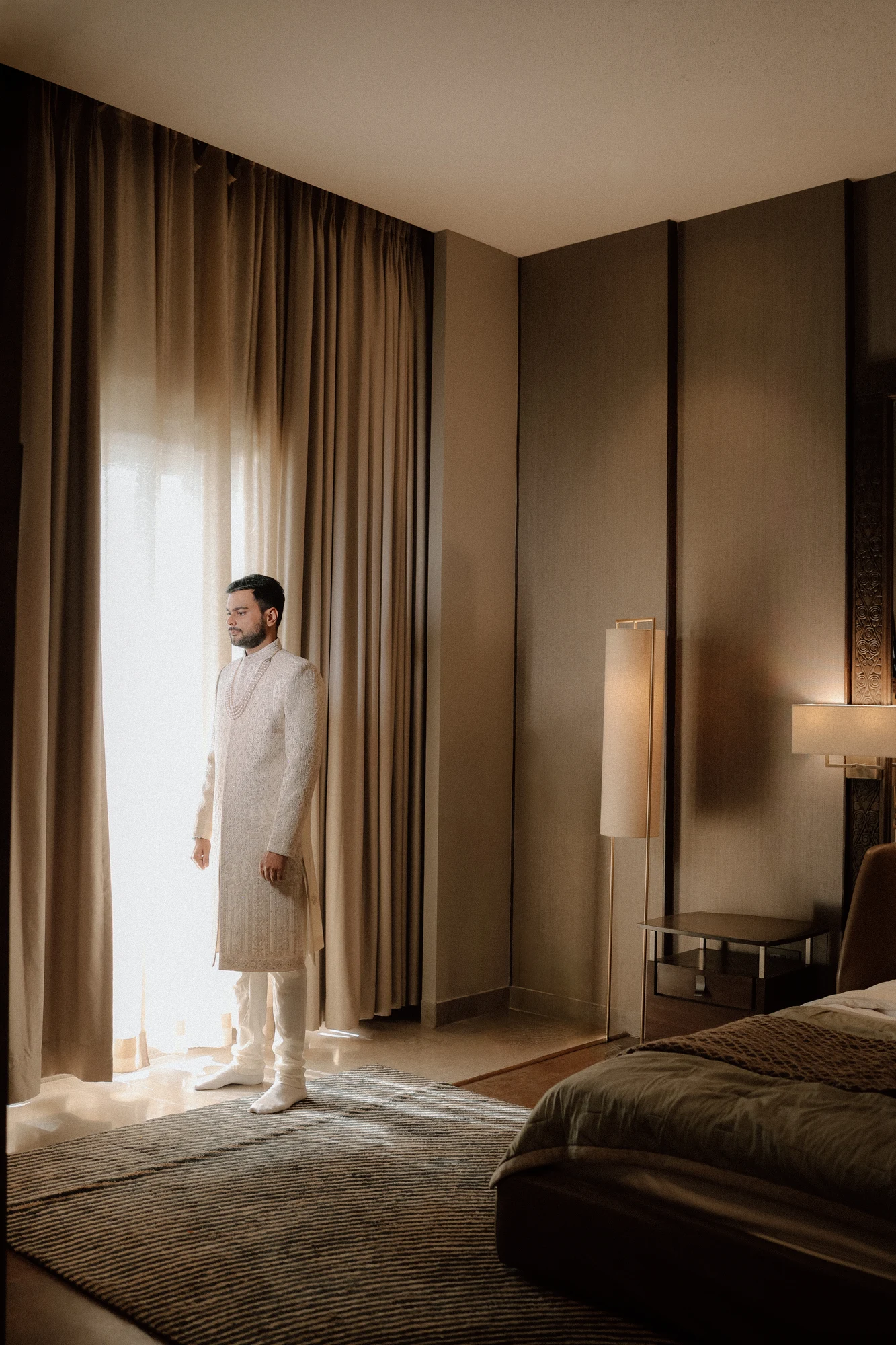 Groom by window drapery