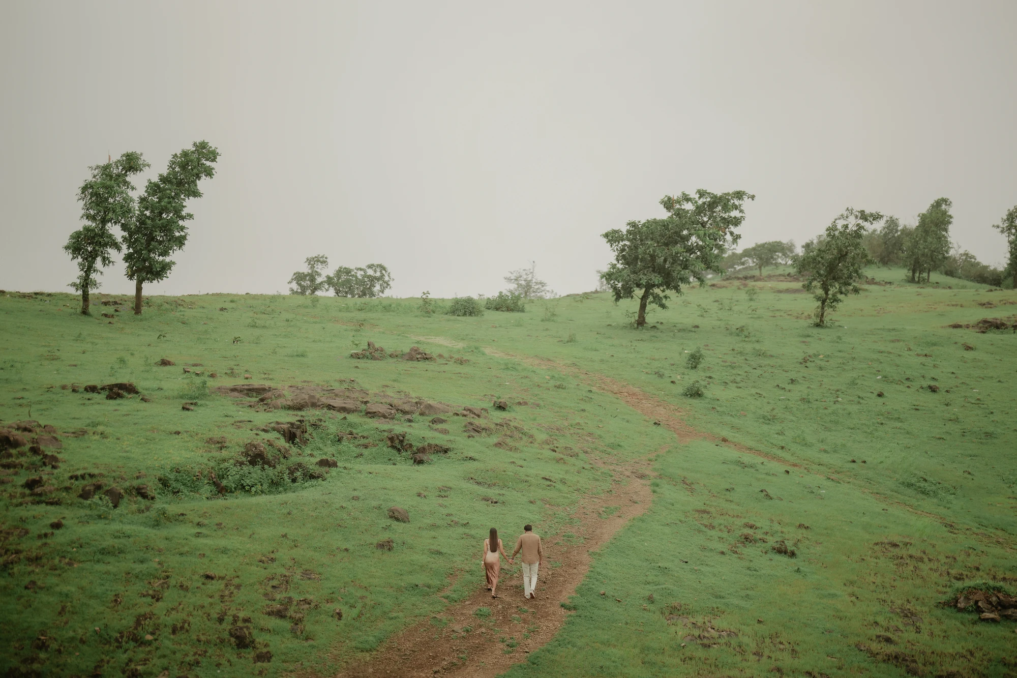 Couple walking across green hills